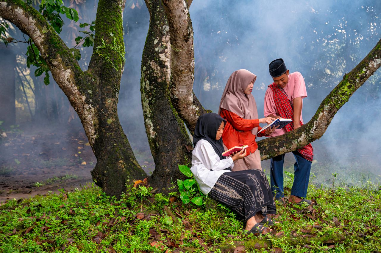 Crafting Captivating Headlines: Your awesome post title goes here Indonesian teens reading together in a serene outdoor setting, promoting education and culture.